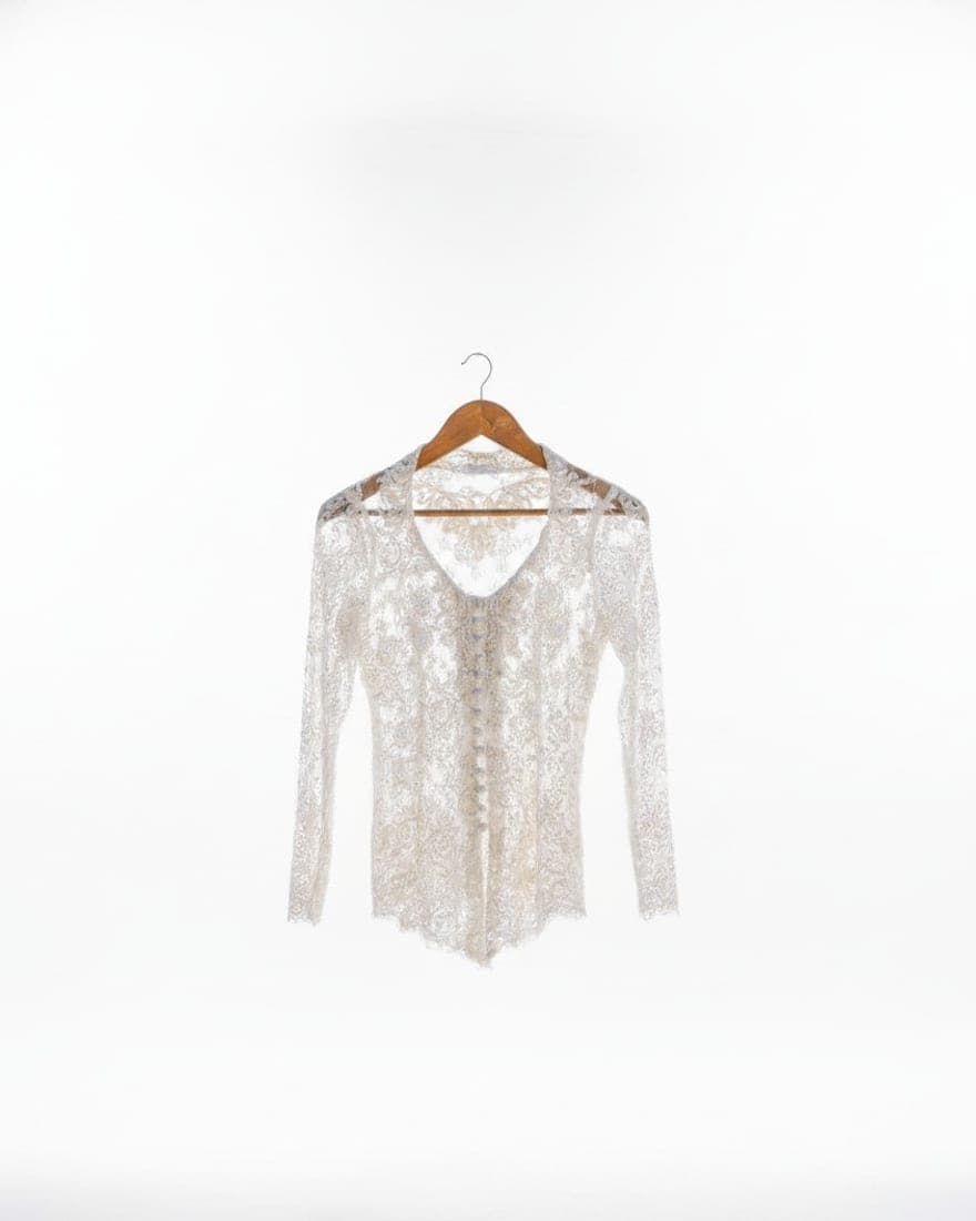 A white lace blouse as a studio photo, with its openwork and sheer sleeves intact